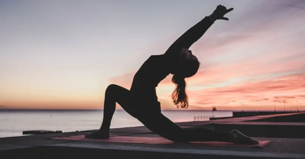 woman doing yoga in sunset