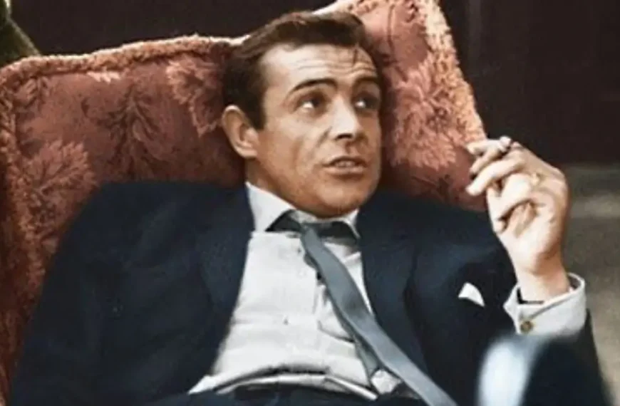 men in suit lying on sofa and is smoking a cigarette